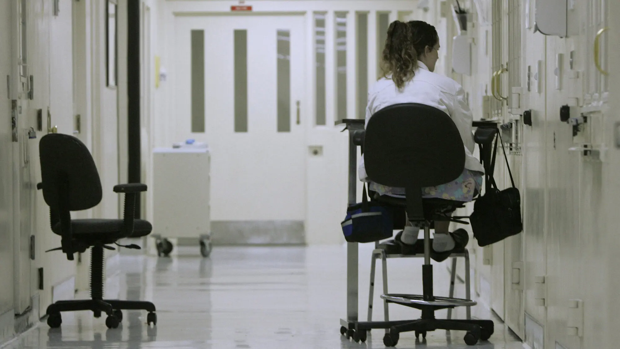 In this March 30, 2008 file photo, medical worker Theresa Wilks keeps a vigil outside an isolation cell containing an inmate who authorities fear might attempt suicide, at California State Prison - Sacramento in Folsom.