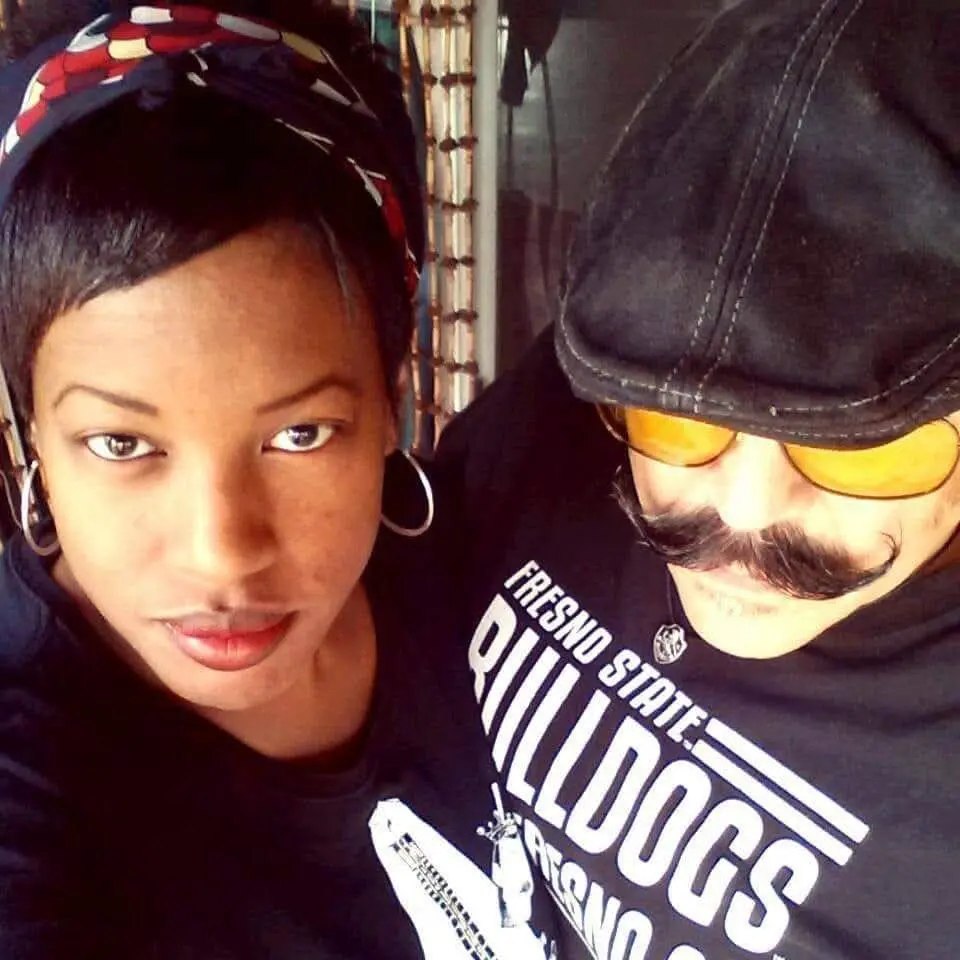 Woman with red lipstick and man with yellow sunglasses and a mustache