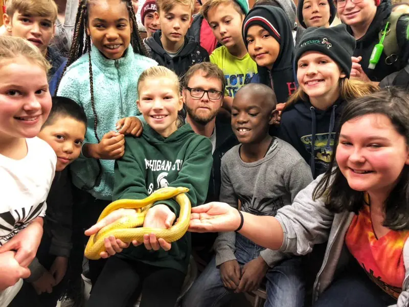 A group of students hold a snake
