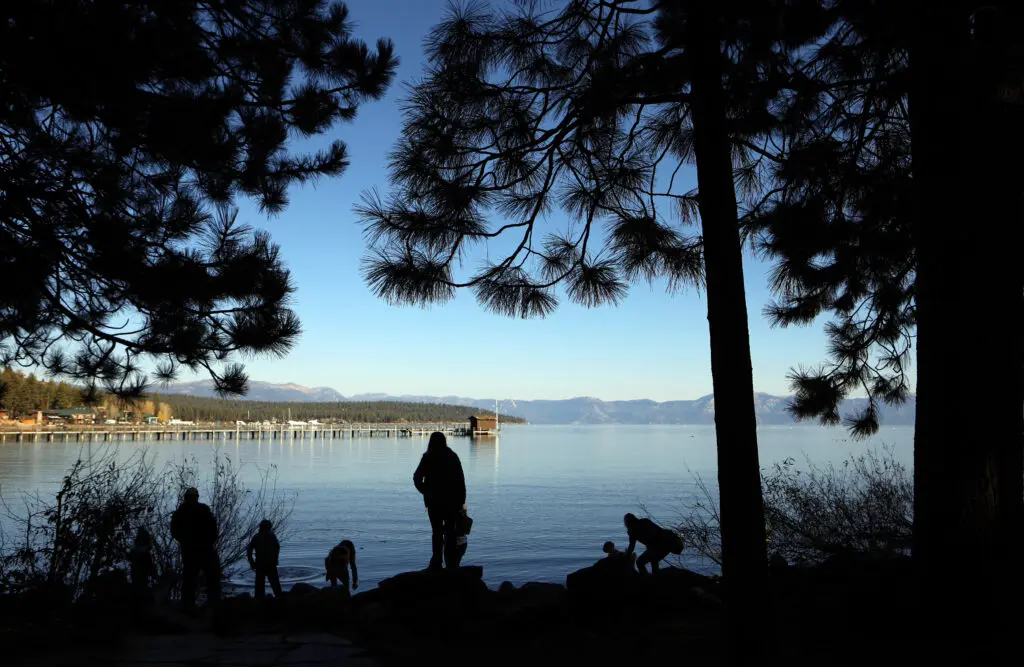 People stand on the shores of Lake Tahoe in Tahoe City