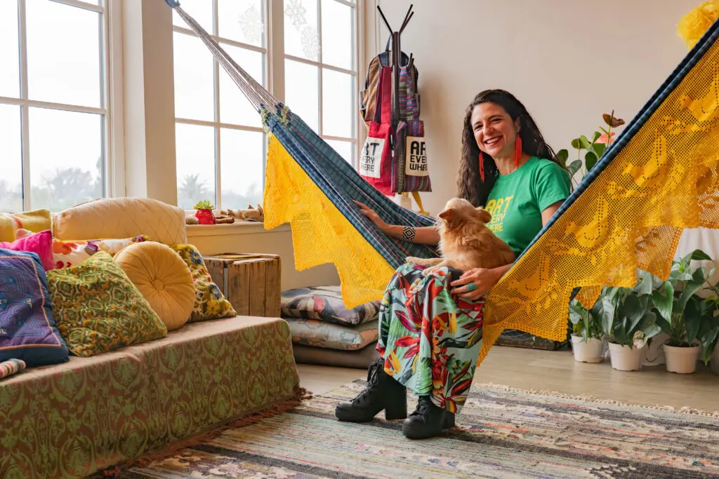 woman sits on hammock with dog