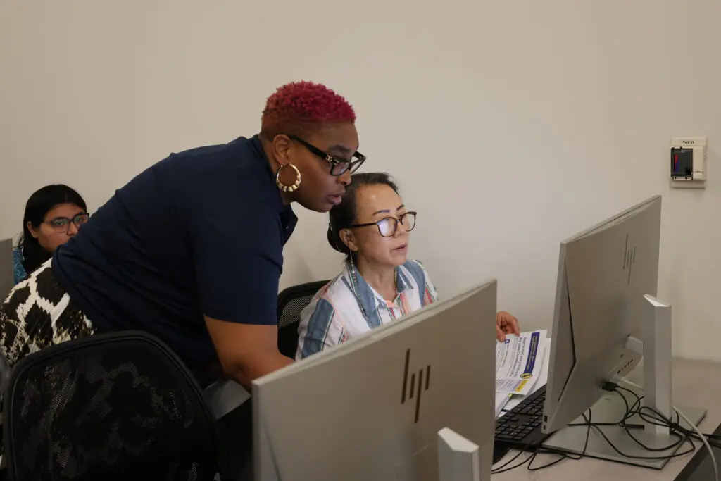 two women look at a computer