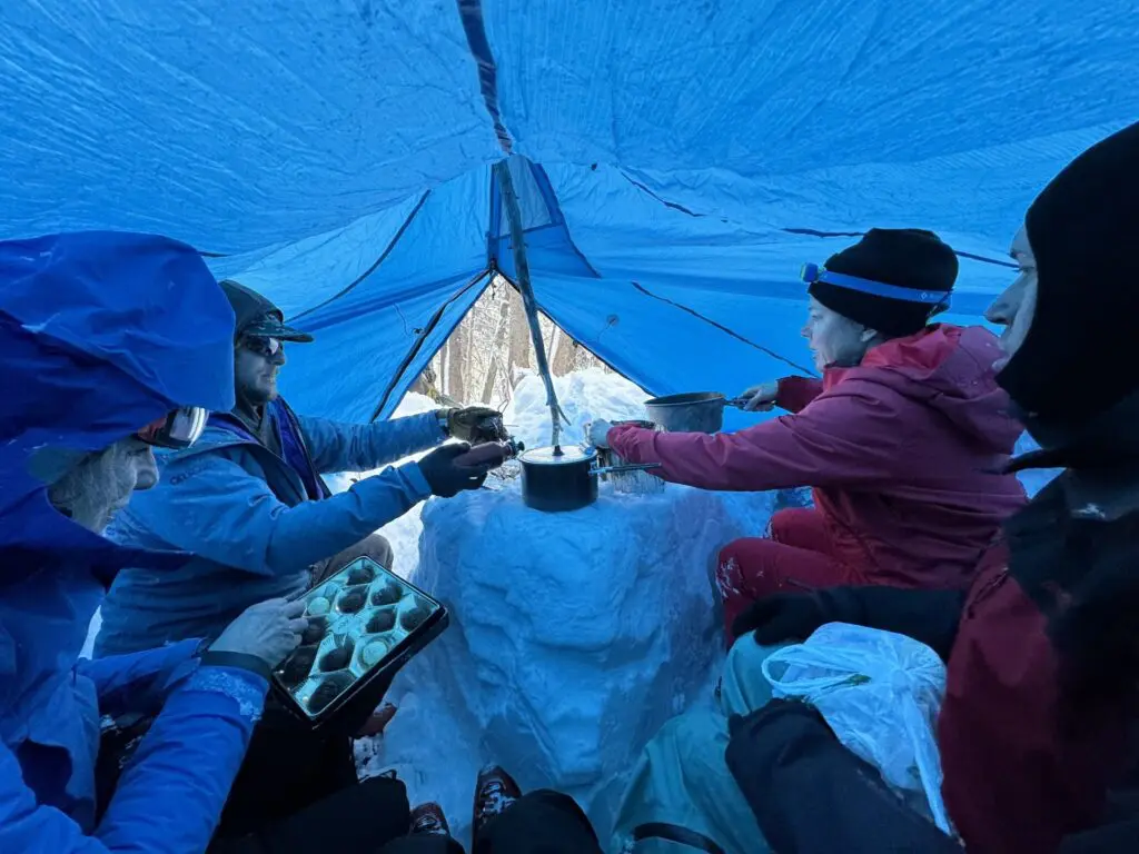 Four people in a tent with snow