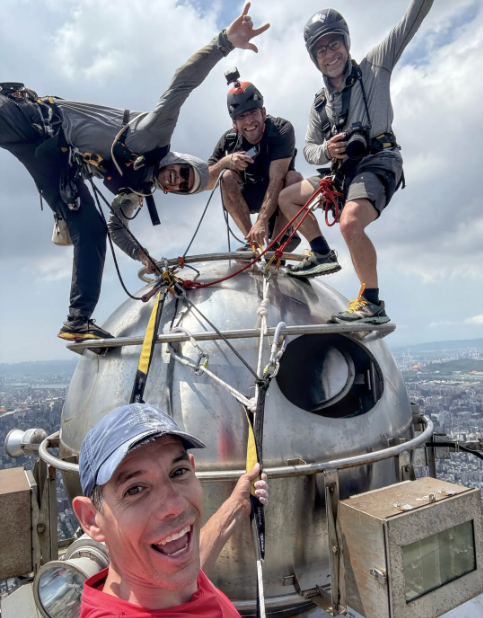 Alex Honnold, bottom center, and three men on top of Taipei 101