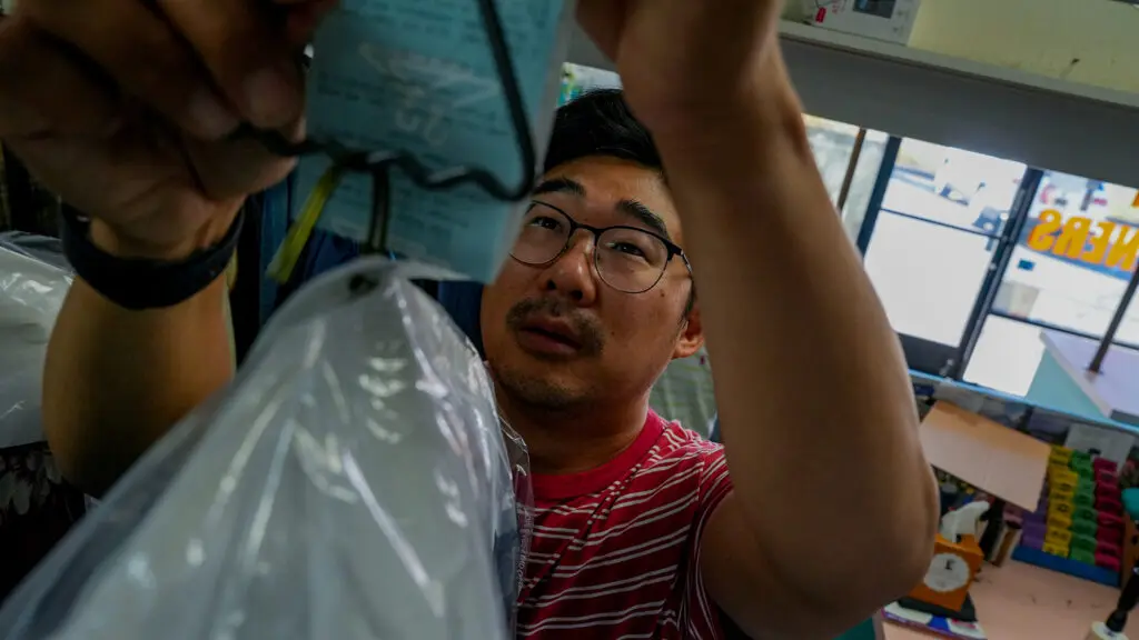 Enoch Ku working at Vogue Cleaners, his family business. Photo by Denis Akbari.