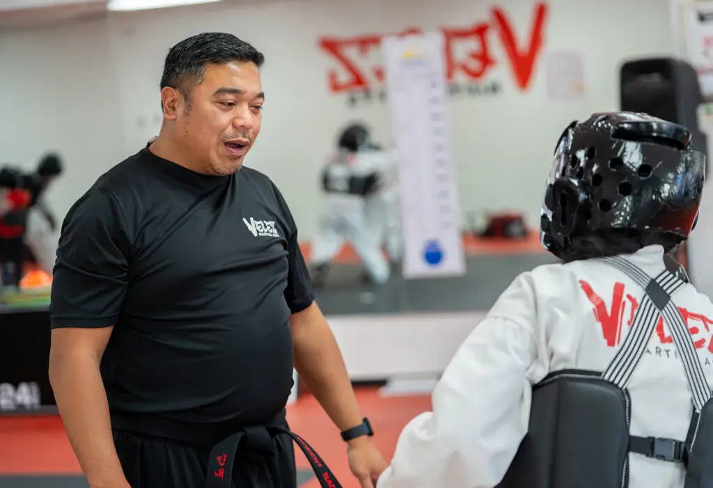 An instructor teaching a taekwondo class