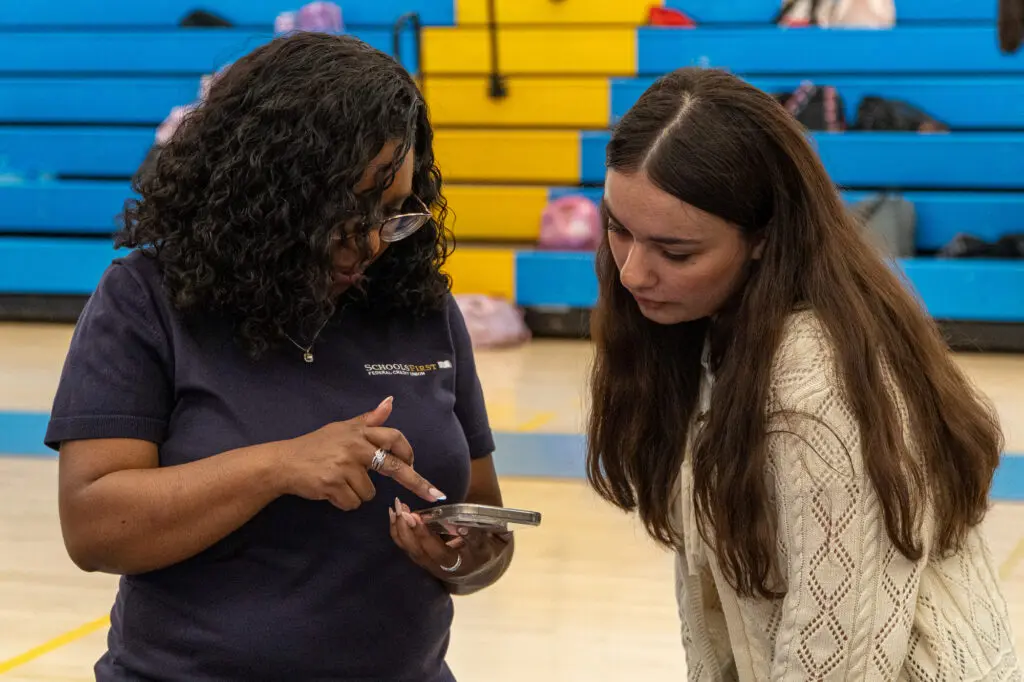 Woman and students looking at phone