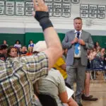 Man raises hand in a meeting.