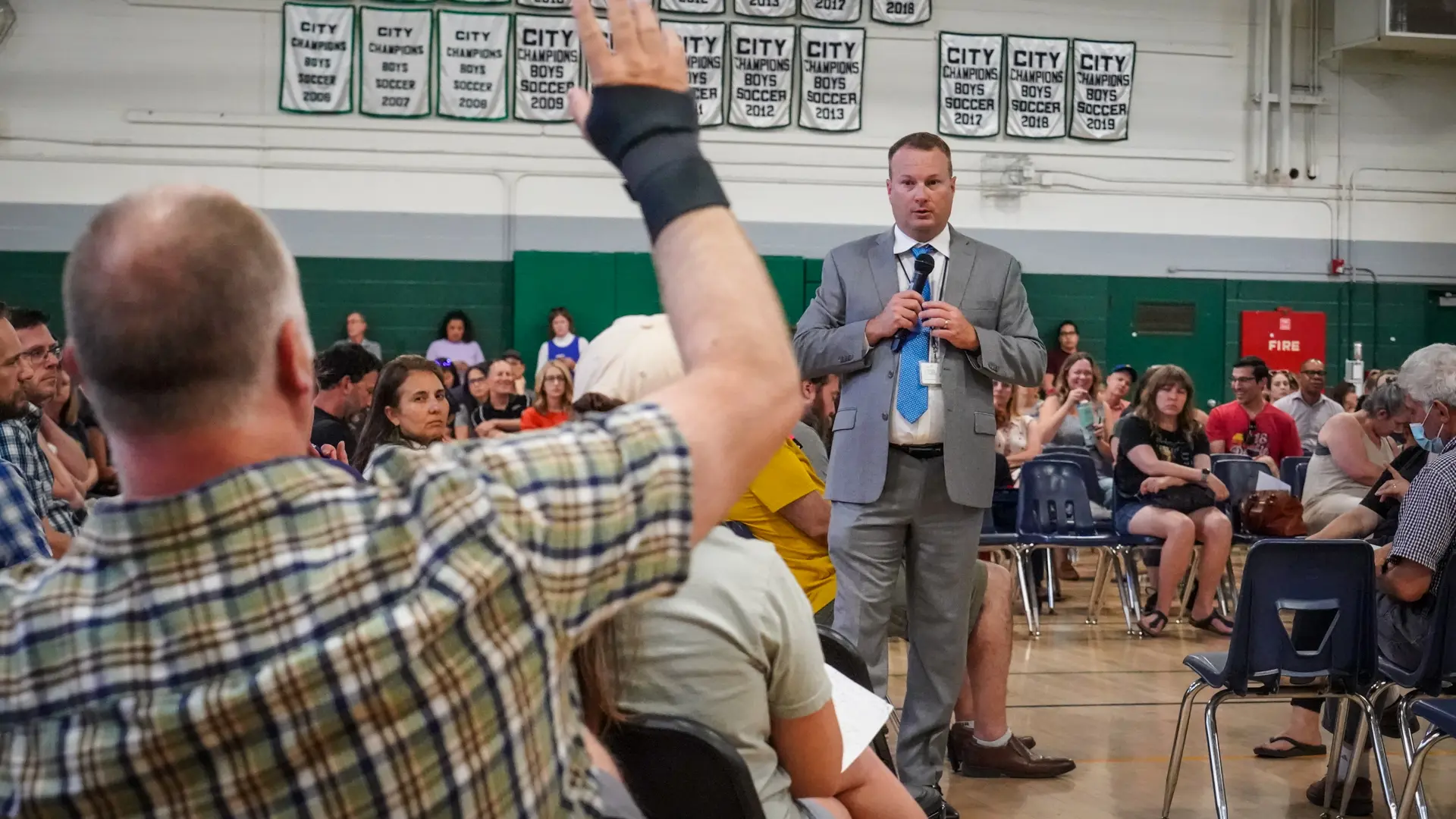 Man raises hand in a meeting.