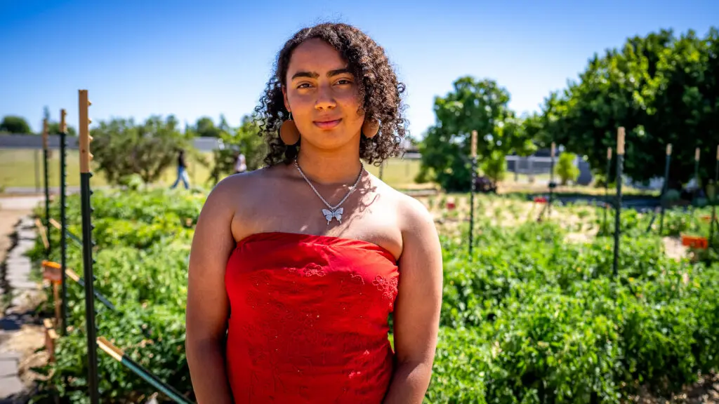 Student in front of garden