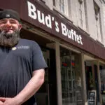 man standing outside shop