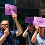 Workers hold up signs