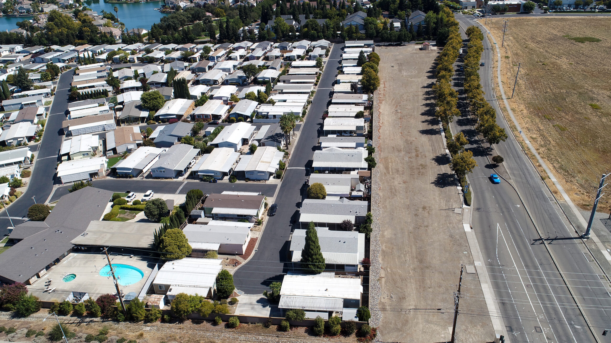 Aerial view of rows of mobile homes near a slim dirt lot