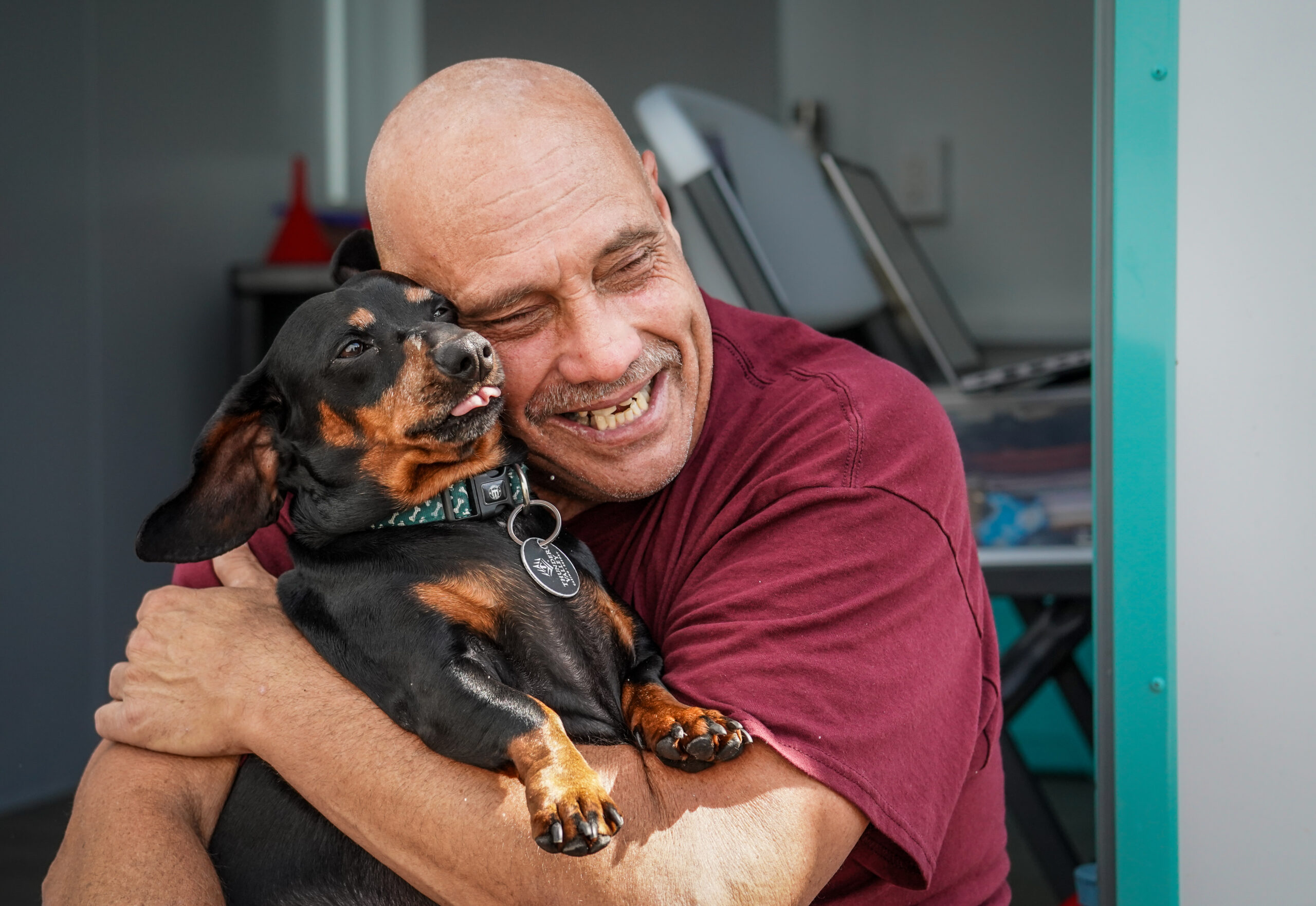 Man grins and holds his dog