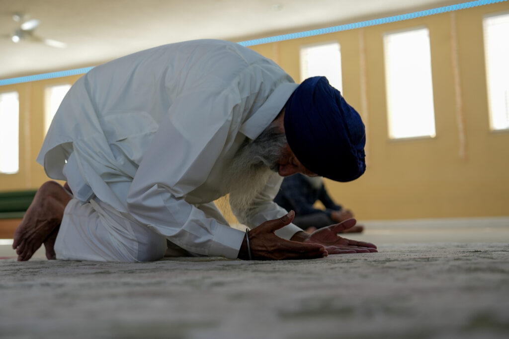 People praying at Gurdwara Sri Sachkhand Sahib, a Sikh temple on 1090 Main St. in Roseville.