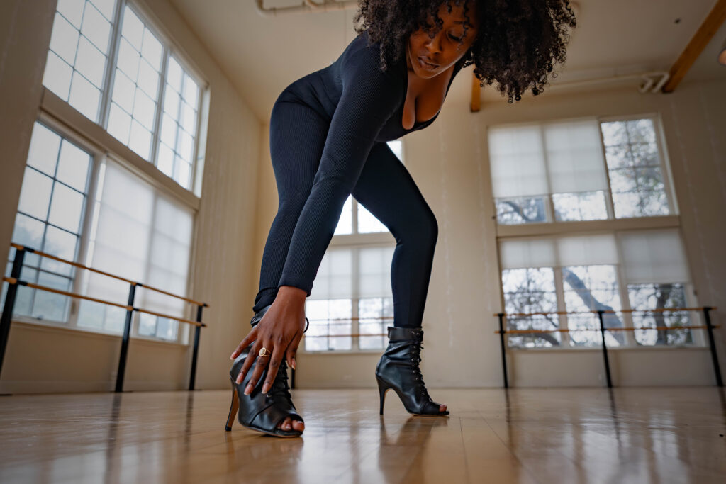 dancer reaches down to touch heels