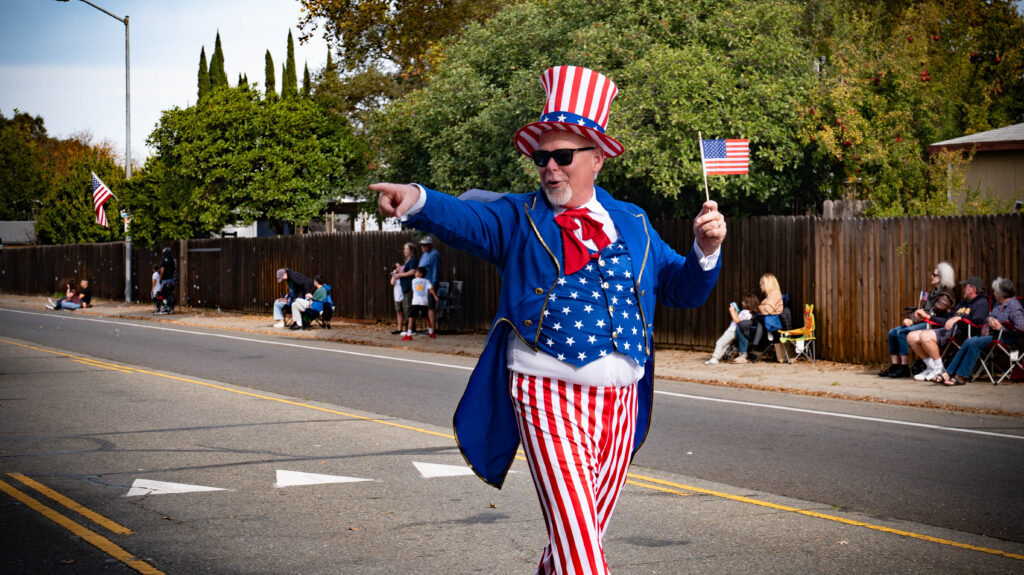 man in patriotic outfit looks at crowd