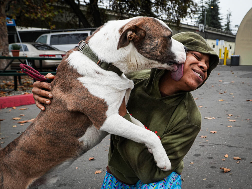 A homeless woman is licked by a dog 