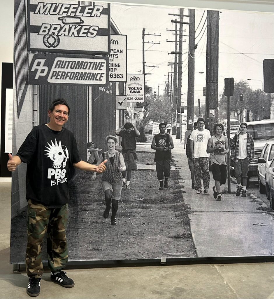 Chris Macias at "Hail Murray" event wearing a PBS is Punk t-shirt.