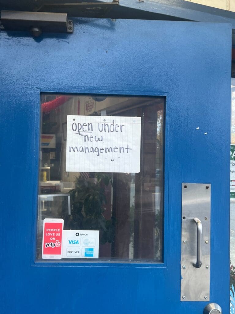 sign reading open under new management