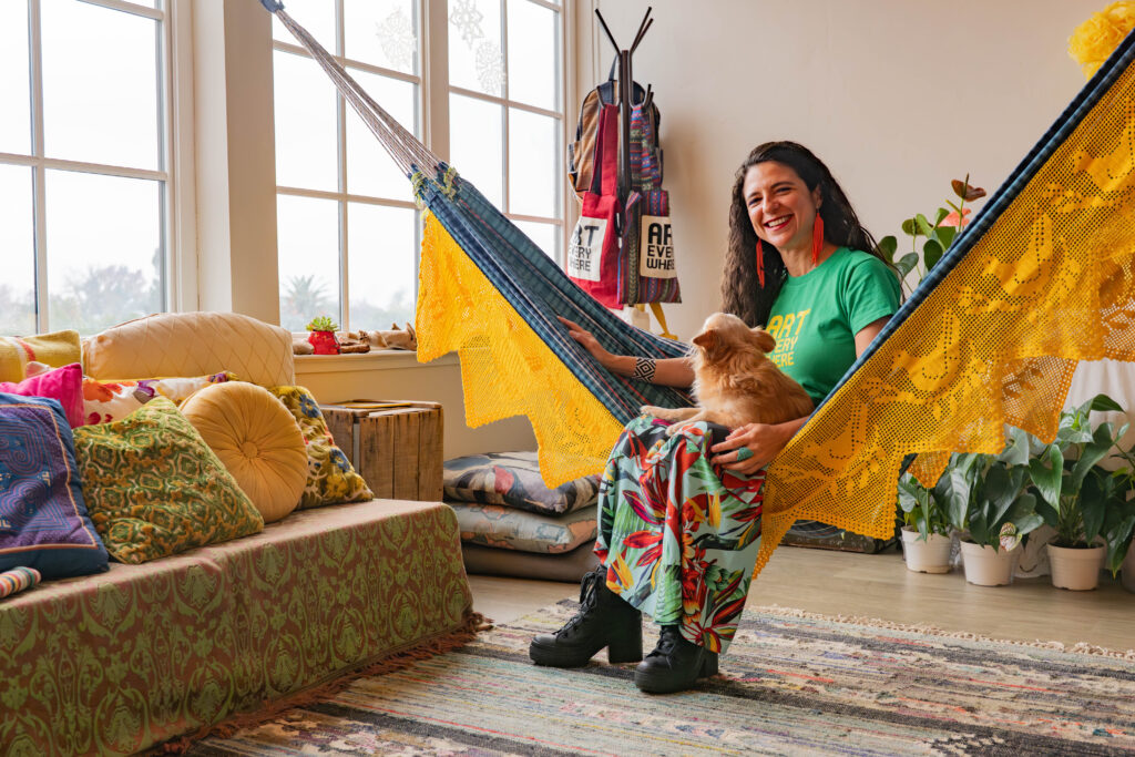woman sits on hammock with dog