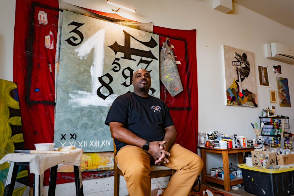 man sitting in front of painting