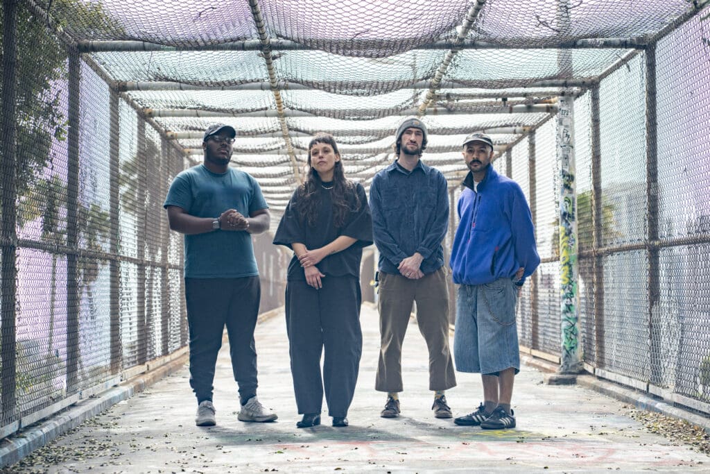 A band poses on a bridge