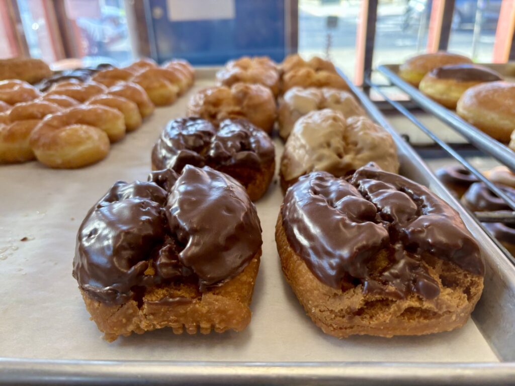 Rows doughnuts line a sheet.