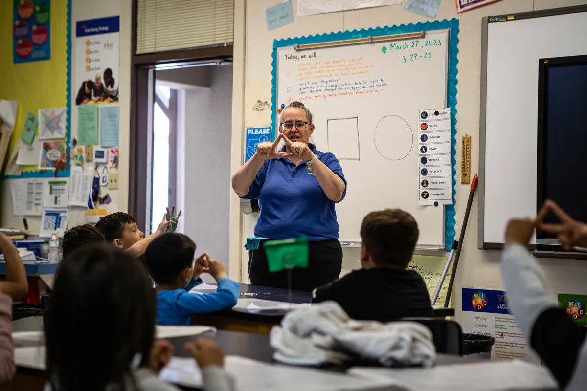 A teacher stands in front of the class.