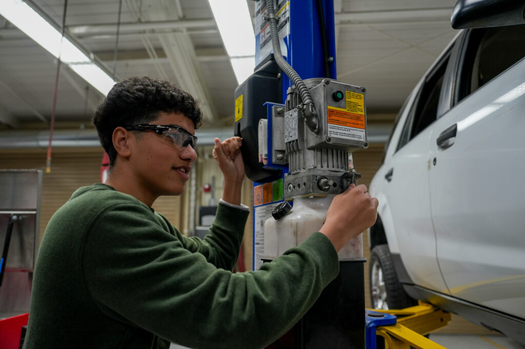 Niaz Mohammadi, San Juan High School student, in an automotive class lowering a car on Jan. 20. Photo by Denis Akbari.