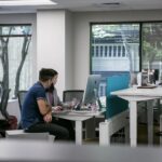 Journalists sit at a desk in an open office space.