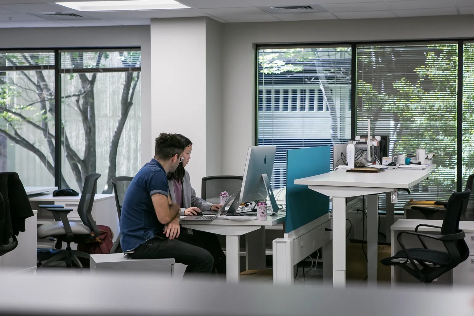 Journalists sit at a desk in an open office space.
