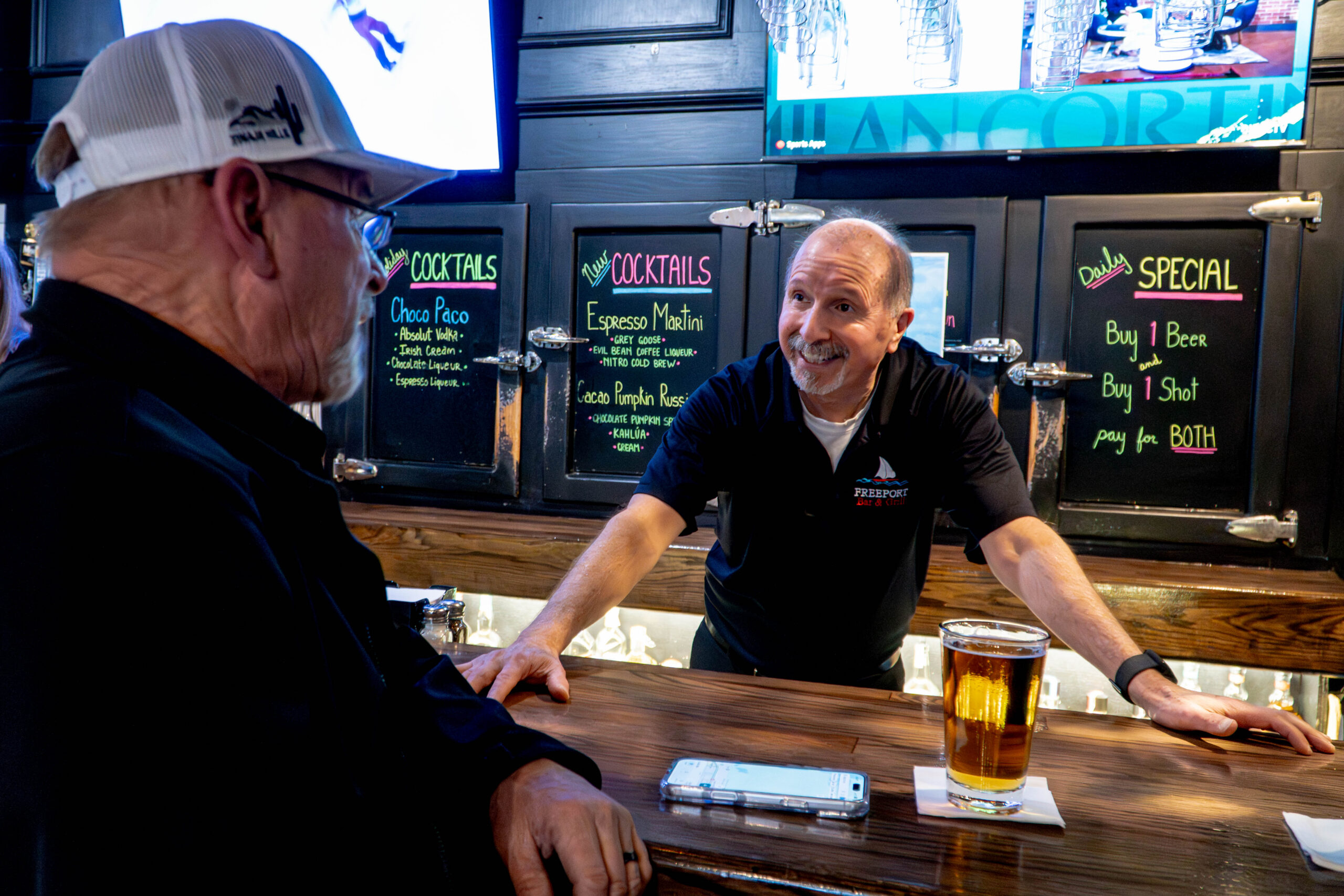 Bartender talking to customer.