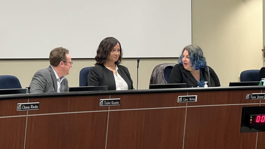 Three people sitting at a dais.