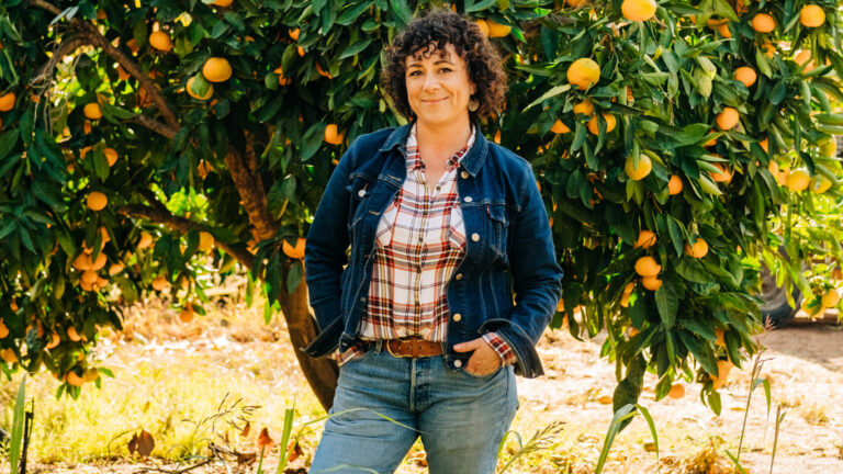 Woman stands in front of tree