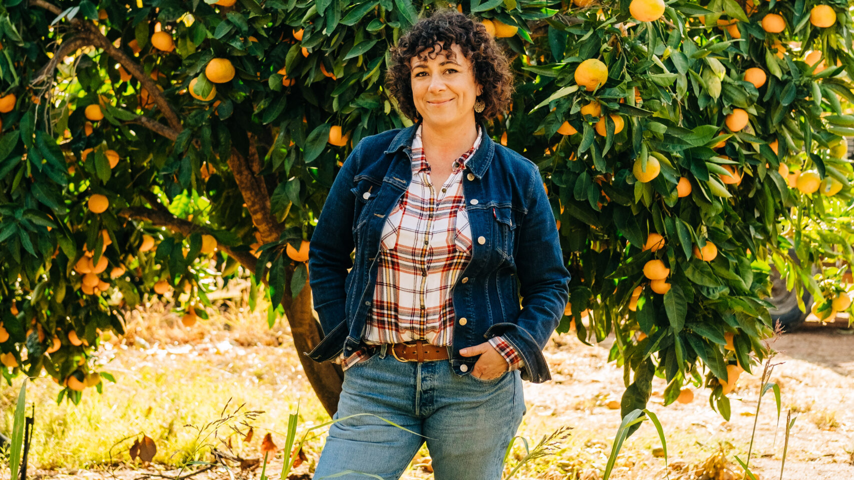 Woman stands in front of tree