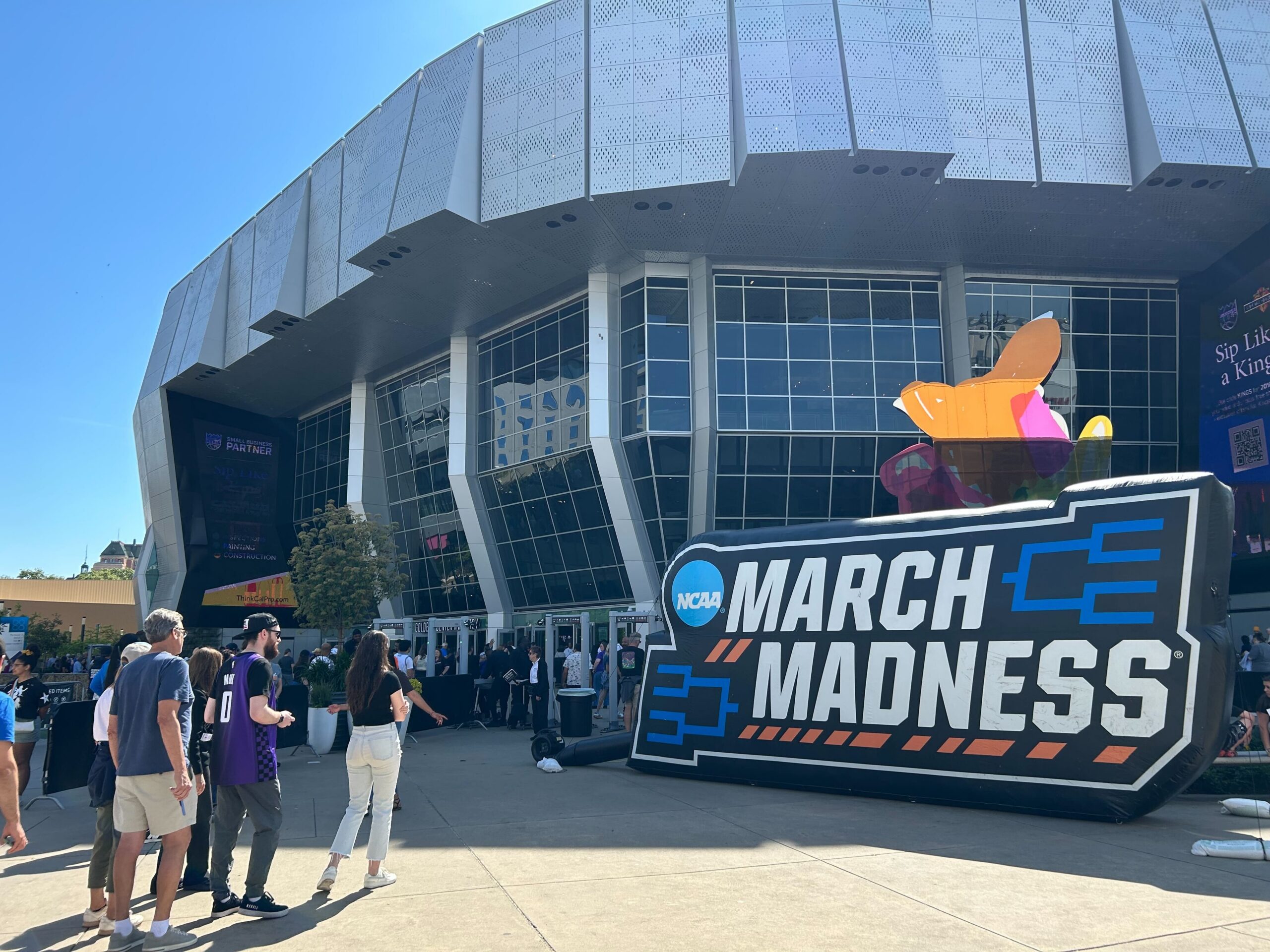 Sports fans line up outside Golden 1 Center and March Madness signage