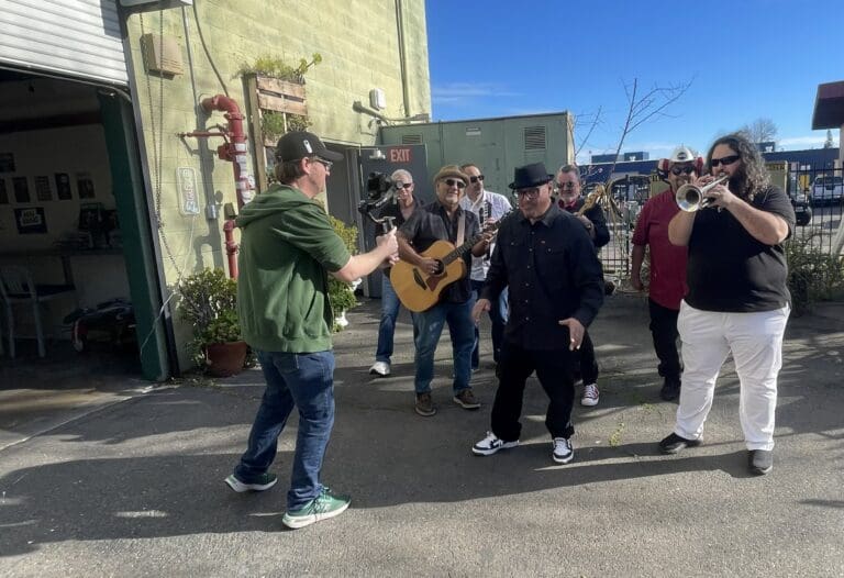 Band members hold instruments and pose
