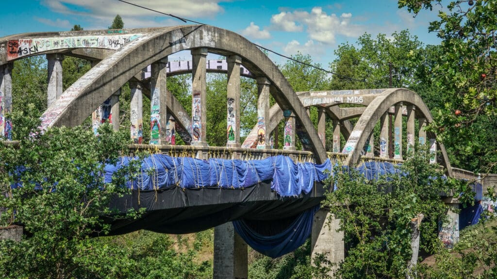 Blue tarps line the side of Stevenson Bridge