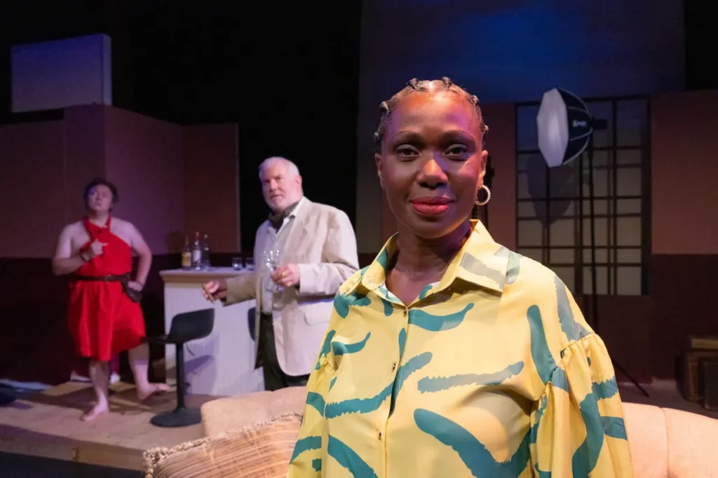 Woman poses on a stage in front of actors