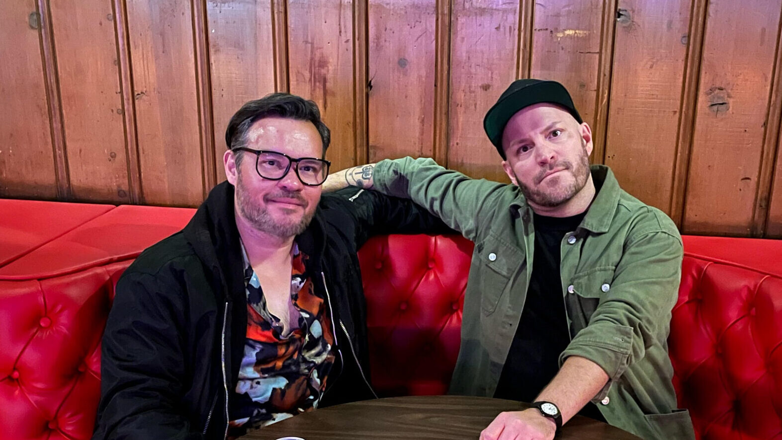 Two men sit in a booth