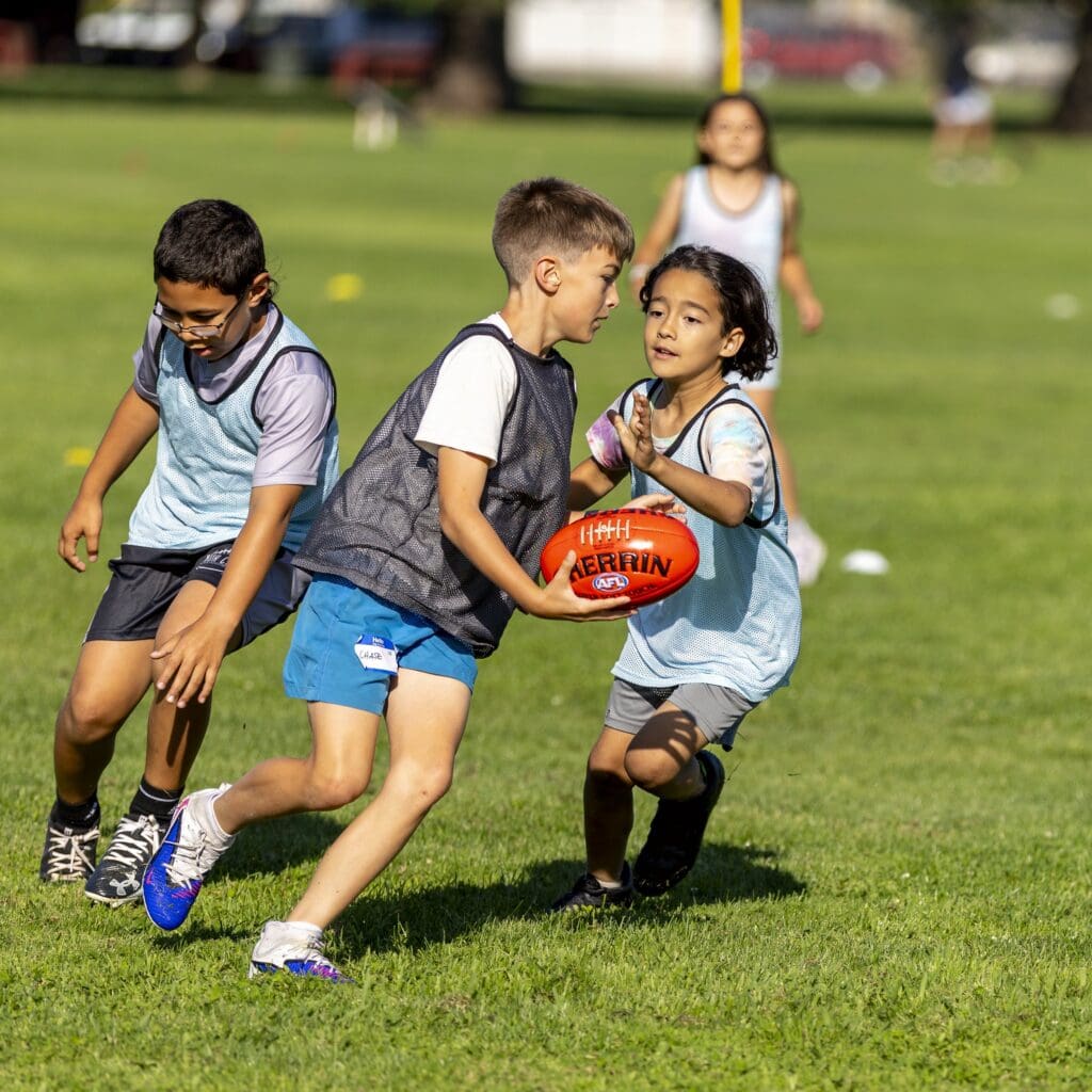 Kids play Australian football