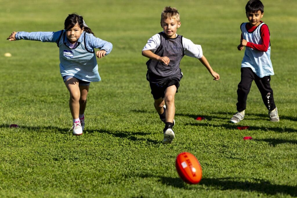 Kids play Australian football
