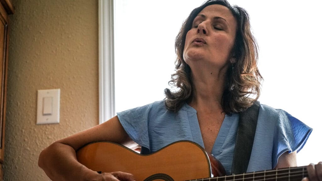 Woman singing and playing guitar