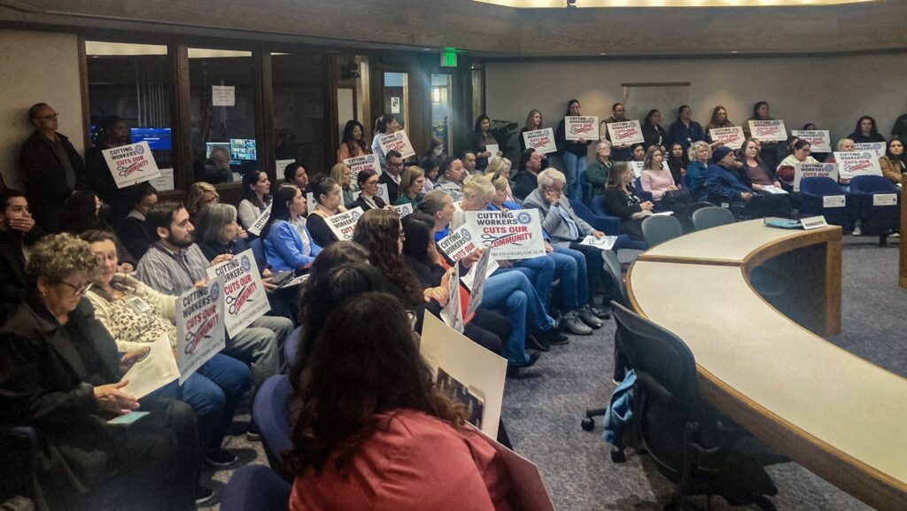 people holding signs at a meeting