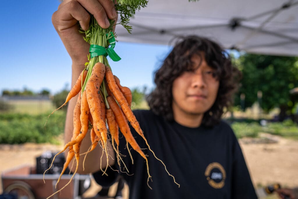 Kid holding up carrots