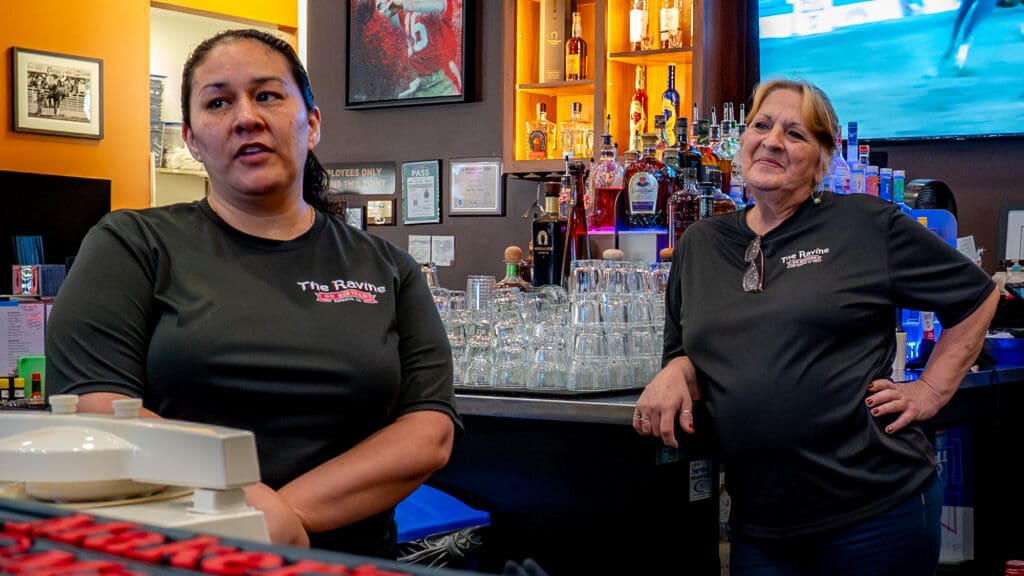Women standing behind bar