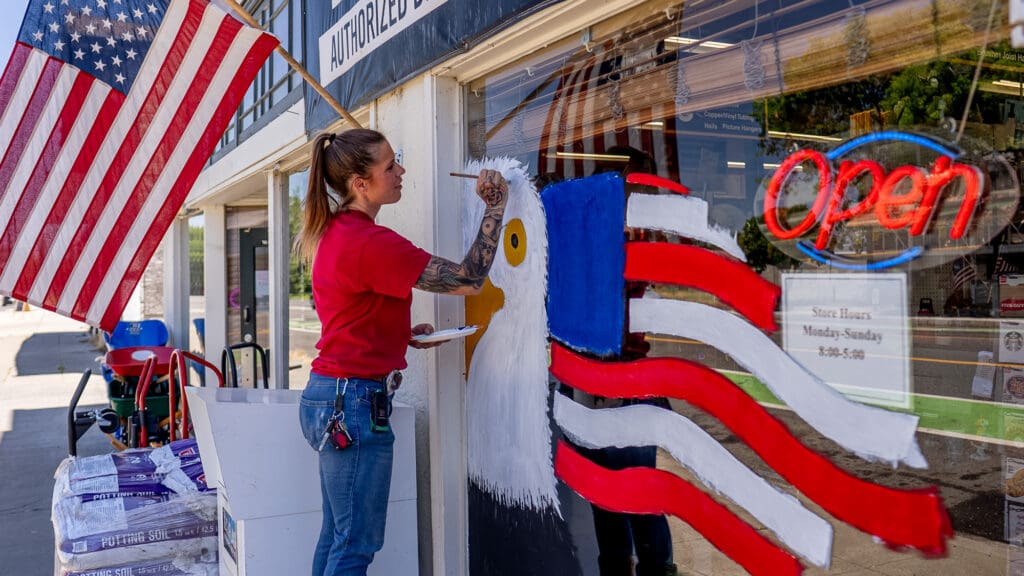 woman painting storefront