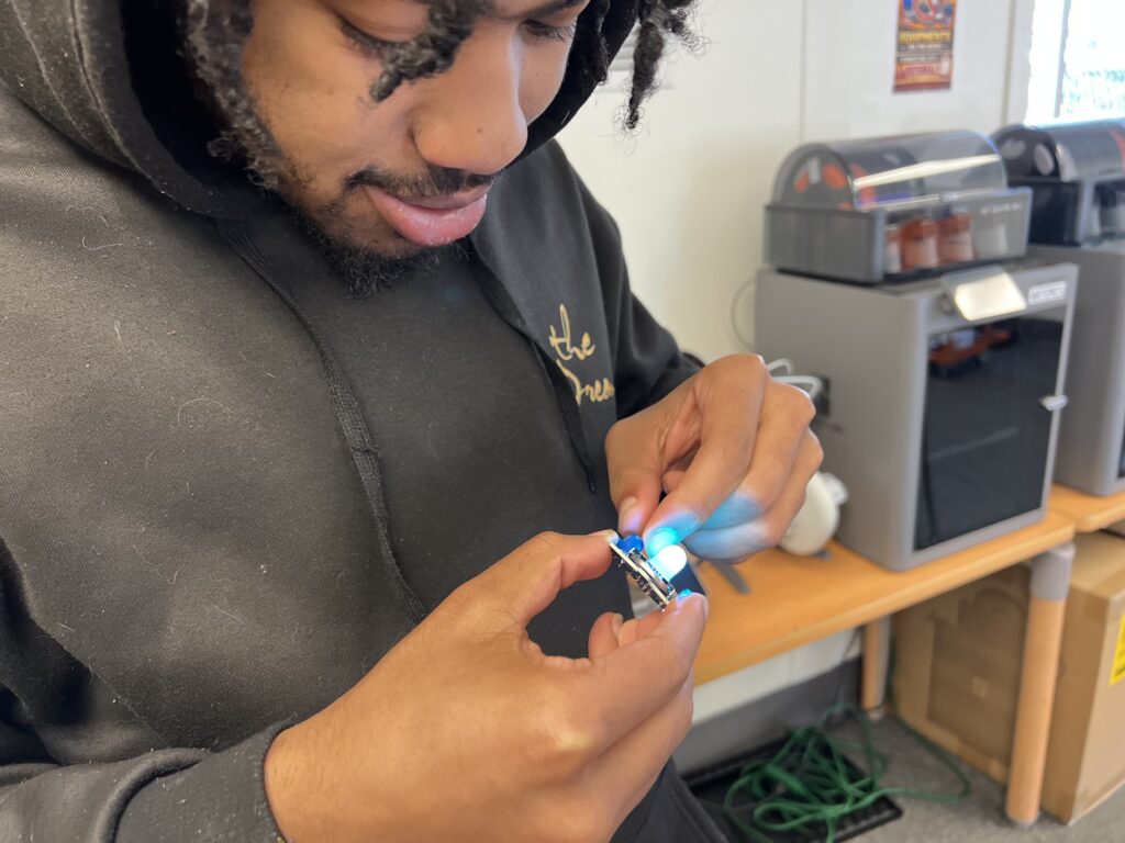 Student Sean Jefferson, 19, tests out a circuit board.