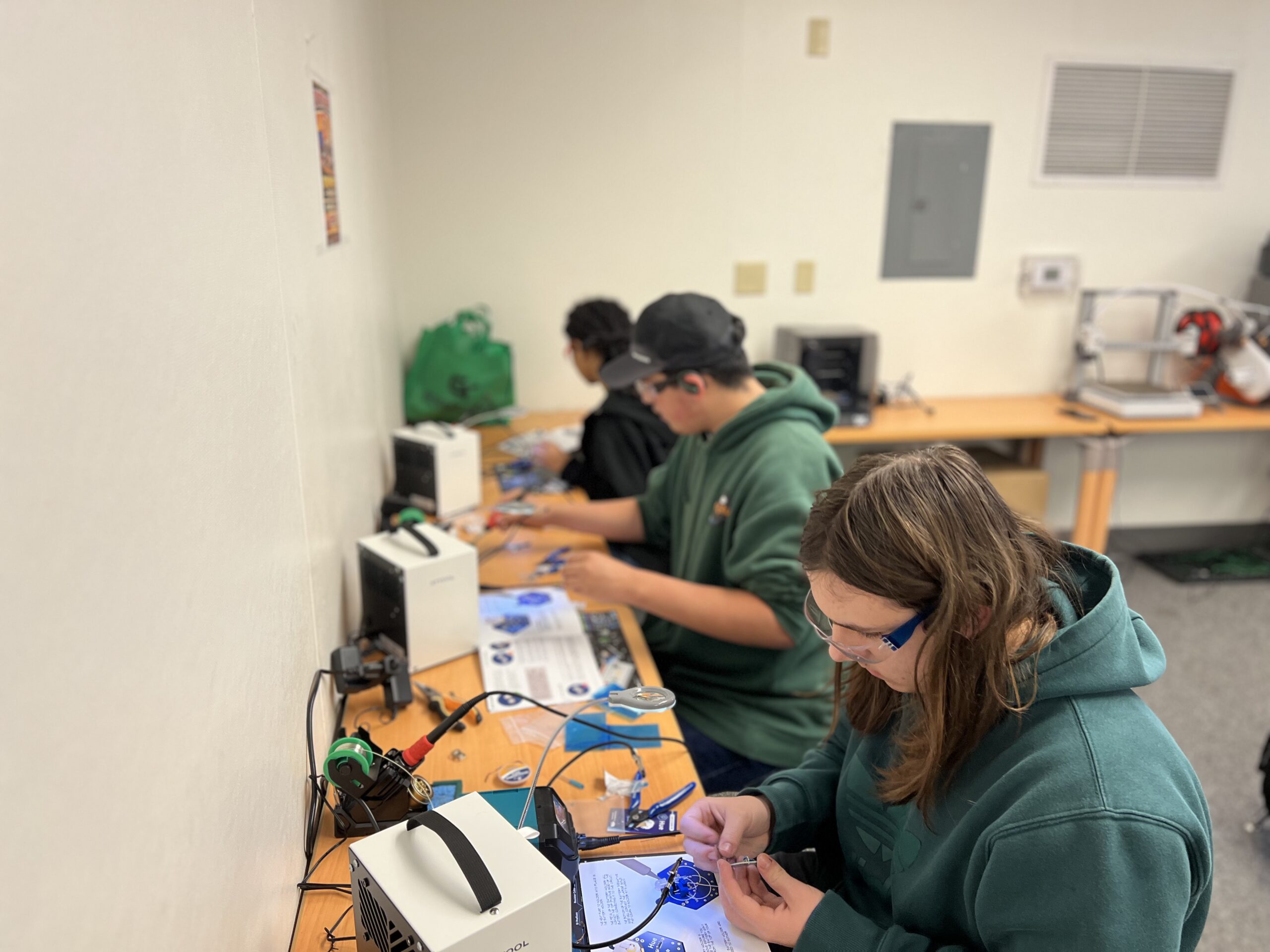 Students work on a printed circuit board.